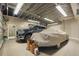 Spacious garage featuring tile flooring, a truck, and car covered with a car cover at 8518 Quail Hollow Blvd, Wesley Chapel, FL 33544