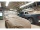 Spacious garage featuring tile flooring and a truck; car covered with a car cover at 8518 Quail Hollow Blvd, Wesley Chapel, FL 33544