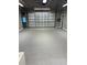 Spacious garage featuring gray tile flooring and large garage door at 8518 Quail Hollow Blvd, Wesley Chapel, FL 33544