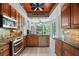 Kitchen with stainless steel appliances, granite countertops, backsplash, wood ceiling, and pool view at 8518 Quail Hollow Blvd, Wesley Chapel, FL 33544