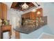 Kitchen with granite counters, breakfast bar, stainless steel appliances and wooden ceiling feature at 8518 Quail Hollow Blvd, Wesley Chapel, FL 33544