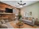 Comfortable living room featuring a ceiling fan, decorative wood wall and seating at 8518 Quail Hollow Blvd, Wesley Chapel, FL 33544
