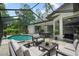 Outdoor space with screened pool, outdoor seating, and a dining area at 8518 Quail Hollow Blvd, Wesley Chapel, FL 33544