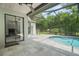 Screened-in pool area featuring an in-ground pool and a tiled deck at 8518 Quail Hollow Blvd, Wesley Chapel, FL 33544