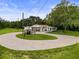 An aerial view of the property featuring a circular driveway and a white home surrounded by lush greenery at 8540 Roseanne Blvd, New Port Richey, FL 34654