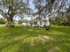 Lush backyard with mature tree shading the house, blending nature and living space at 8540 Roseanne Blvd, New Port Richey, FL 34654