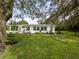 Backyard view highlighting the green lawn and landscaping around the home at 8540 Roseanne Blvd, New Port Richey, FL 34654