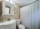 Compact bathroom featuring a sink and toilet combination with a white shower curtain at 8540 Roseanne Blvd, New Port Richey, FL 34654