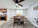 Open concept dining room featuring wood-look flooring, ceiling fan, dining table and view to the kitchen at 8540 Roseanne Blvd, New Port Richey, FL 34654