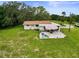 Aerial shot of the back of a home, featuring a patio with outdoor seating and a spacious lawn at 8540 Roseanne Blvd, New Port Richey, FL 34654