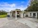 Home exterior with covered patio, pavers, and a well-maintained yard under a blue sky at 8540 Roseanne Blvd, New Port Richey, FL 34654
