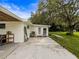Exterior of home, showing a well-kept lawn, patio area, and a mature tree at 8540 Roseanne Blvd, New Port Richey, FL 34654