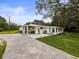 The rear exterior of the home, featuring a paver driveway, patio, and a lush green lawn at 8540 Roseanne Blvd, New Port Richey, FL 34654