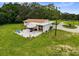 Aerial view showing outdoor patio area with umbrella and slide, surrounded by a large lawn at 8540 Roseanne Blvd, New Port Richey, FL 34654