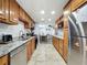 Traditional kitchen featuring granite countertops, wood cabinetry, stainless steel appliances and tile flooring at 8540 Roseanne Blvd, New Port Richey, FL 34654