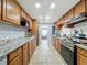 Traditional kitchen featuring stainless steel appliances, wood cabinetry, granite countertops, and tile flooring at 8540 Roseanne Blvd, New Port Richey, FL 34654