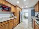 Kitchen featuring granite countertops, stainless steel appliances, wood cabinets, and tile flooring at 8540 Roseanne Blvd, New Port Richey, FL 34654