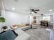 Bright and spacious living room leading to dining area, featuring neutral paint, ceiling fans and a rug at 8540 Roseanne Blvd, New Port Richey, FL 34654