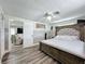 Charming main bedroom with wood-look floors, fan, and view into the living room at 8540 Roseanne Blvd, New Port Richey, FL 34654