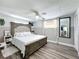 Stylish main bedroom with wood-look floors, fan, and access to ensuite bathroom at 8540 Roseanne Blvd, New Port Richey, FL 34654