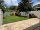 Backyard featuring a well maintained green lawn, a concrete patio, and a white fence at 930 Woodbridge Ct, Safety Harbor, FL 34695