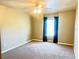 Standard bedroom featuring neutral carpeting, a ceiling fan, and a window with curtains at 930 Woodbridge Ct, Safety Harbor, FL 34695