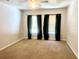 Simple bedroom with neutral carpeting and a window with dark curtains at 930 Woodbridge Ct, Safety Harbor, FL 34695