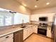 Bright kitchen featuring white cabinets, stainless steel appliances, granite countertops, and a breakfast bar at 930 Woodbridge Ct, Safety Harbor, FL 34695