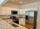 Bright kitchen with stainless steel appliances, white cabinets, granite countertops and backsplash at 930 Woodbridge Ct, Safety Harbor, FL 34695