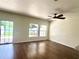 Living room featuring wood flooring, a ceiling fan, and sliding glass doors to the backyard at 930 Woodbridge Ct, Safety Harbor, FL 34695