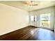 Bright living room featuring hardwood floors, a ceiling fan, and a large window for natural light at 930 Woodbridge Ct, Safety Harbor, FL 34695