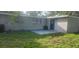 View of the building's exterior with a sliding glass door leading to a small concrete patio at 9432 84Th St, Seminole, FL 33777