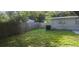 Spacious backyard with a wood fence, grassy area, and the building's exterior at 9432 84Th St, Seminole, FL 33777