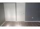 Bedroom featuring neutral walls, wood-look floors, closet, and door at 9432 84Th St, Seminole, FL 33777