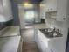 Clean kitchen boasts white cabinets, a stainless steel sink and open access to another room, enhancing a home's appeal at 9432 84Th St, Seminole, FL 33777
