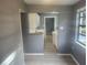 Cozy kitchen featuring white cabinets, a window and an open doorway with vinyl flooring at 9432 84Th St, Seminole, FL 33777