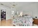 Bright bedroom with wood floors, seashell-themed decor, and ensuite bathroom and walk-in closet at 10093 Holly Berry Dr, Weeki Wachee, FL 34613