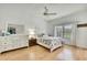 Bright bedroom with wood floors, white furniture, and a window overlooking a green space at 10093 Holly Berry Dr, Weeki Wachee, FL 34613