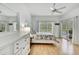 Bright bedroom with wood floors, white furniture, window, and sliding door access to pool at 10093 Holly Berry Dr, Weeki Wachee, FL 34613