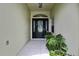 Inviting entrance featuring a decorative glass front door and lush greenery, creating a warm welcome at 10093 Holly Berry Dr, Weeki Wachee, FL 34613