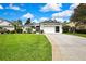 Inviting single-story home with a well-maintained lawn, long driveway, and attached two-car garage at 10093 Holly Berry Dr, Weeki Wachee, FL 34613