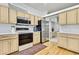 Well-lit kitchen featuring wood cabinets, stainless steel appliances, and a view into the next room at 10093 Holly Berry Dr, Weeki Wachee, FL 34613