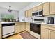 Modern kitchen with stainless steel appliances, light wood cabinets, and a cozy dining area at 10093 Holly Berry Dr, Weeki Wachee, FL 34613