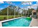 Relaxing in-ground pool enclosed by a screen with a view of the lush, green backyard at 10093 Holly Berry Dr, Weeki Wachee, FL 34613