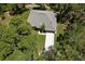 Aerial view of a home's roof and driveway nestled among lush trees at 10149 Rockbay Rd, Brooksville, FL 34601