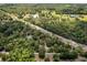 An aerial landscape shot featuring a pond and scattered houses among wooded acreage at 10149 Rockbay Rd, Brooksville, FL 34601