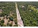 A wide aerial landscape features power lines bisecting wooded land and houses at 10149 Rockbay Rd, Brooksville, FL 34601