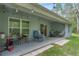 Covered back porch is furnished with chairs and tables that offer an ideal outdoor lounging area at 10149 Rockbay Rd, Brooksville, FL 34601