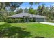 Inviting single-story home featuring a well-manicured lawn, lush shrubbery, and a freshly painted exterior at 10149 Rockbay Rd, Brooksville, FL 34601