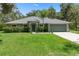 Charming single-story home with lush green lawn and meticulously maintained landscaping and a side entry garage at 10149 Rockbay Rd, Brooksville, FL 34601